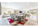 Bright dining room with a long table, tile floors, and backyard view from big window at 397 American Dipper St, Las Vegas, NV 89138