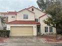 Two-story home with a red tile roof, attached two-car garage and desert landscaping at 417 Raindance Dr, Henderson, NV 89014