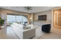 Bright living room featuring modern furniture, neutral tones, and large sliding glass doors to outdoor patio at 463 Harmony Bay Ave, Las Vegas, NV 89138