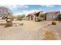 Charming Southwestern-style home with a stucco exterior, desert landscaping, and tile roofing at 519 N Racetrack Rd, Henderson, NV 89015