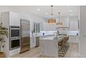 Modern kitchen features stainless steel appliances, marble countertops, and a large island with seating at 5225 Villa Dante Ave, Las Vegas, NV 89141