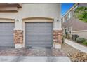 Attached garage with stylish stone accents and brick paver driveway at 5537 Parlay Way # 101, Las Vegas, NV 89122