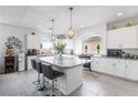 Bright kitchen featuring stainless appliances, white cabinetry, granite counters, a large island, and contemporary pendant lighting at 6346 Rock Strm Ln, Las Vegas, NV 89141