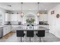 Bright kitchen with white cabinetry, granite countertops, and a large island with bar seating at 6346 Rock Strm Ln, Las Vegas, NV 89141