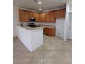 Well-lit kitchen featuring wooden cabinets, stainless steel appliances, and tile flooring at 684 Calamus Palm Pl, Henderson, NV 89011