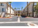 Exterior of condominium buildings surrounded by palm trees and well-maintained landscaping at 7151 S Durango Dr # 211, Las Vegas, NV 89113