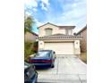 Two-story home with a large two-car garage door and classic desert landscaping at 7640 Highland Pony St, Las Vegas, NV 89149
