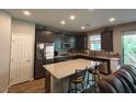 Modern kitchen with granite countertops, stainless steel appliances, and a breakfast bar with stool seating at 8105 Switchback Run St, Las Vegas, NV 89166
