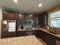 Well-equipped kitchen featuring dark cabinetry, granite countertops, and stainless steel appliances at 8105 Switchback Run St, Las Vegas, NV 89166