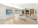 Bright living room features contemporary furnishings, a fireplace, and direct access to the backyard pool at 8305 Woodland Prairie Ave, Las Vegas, NV 89129