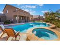 Backyard pool and spa featuring stone accents, lounge chairs, and a patio at 8817 Adobe Grande St, Las Vegas, NV 89131
