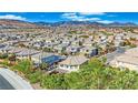 An aerial view of a residential area nestled beneath picturesque mountains and under a beautiful blue sky at 10223 Aragon Crown Rd, Las Vegas, NV 89135