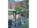Tranquil backyard with desert landscaping, gravel beds, mature cacti, an outdoor living area, and a hot tub at 176 Brighton Hills Ave, Henderson, NV 89002