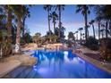 Inviting pool with rock features, lush palm trees, and clear blue water, perfect for relaxation at 2041 Troon Dr, Henderson, NV 89074