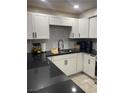 Stylish kitchen boasting modern white cabinets, sleek black countertops, and contemporary fixtures at 3221 Yolanda Ln, Las Vegas, NV 89121
