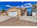 Side view of a home with a large driveway, two-car garage, and low-maintenance landscaping at 4910 Marywood Ct, Pahrump, NV 89061