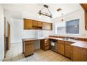 Functional kitchen with oak cabinetry, a stainless steel dishwasher, and tile countertops at 516 Tabony Ave, Henderson, NV 89011