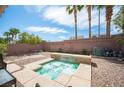 Backyard view with a small jacuzzi-style spa with water feature and low-maintenance desert landscaping at 5615 Believe Ct, Las Vegas, NV 89139