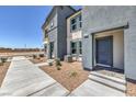Modern townhome exterior showcasing a walkway and well-kept landscaping at 6168 Aster Garden St # 138, North Las Vegas, NV 89081