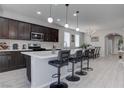 Beautiful kitchen featuring a large island with bar seating, modern appliances, and stylish dark wood cabinetry at 6833 Wispy Sky Ct, Las Vegas, NV 89142