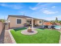 Expansive backyard with a fire pit, artificial grass, patio, and a pool, perfect for outdoor activities at 7420 Zonal Ave, Las Vegas, NV 89131