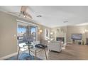 Sun-filled living room with modern decor, wood floors, and glass top desk, with a cozy fireplace at 8600 W Charleston Blvd # 2098, Las Vegas, NV 89117