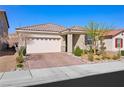 Single-story home showcasing a paver driveway, two-car garage, and mature desert landscaping at 984 Brilliant Meadow Ave, North Las Vegas, NV 89086