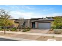 A modern single-story house featuring drought-resistant landscaping and a large brick driveway with a two-car garage at 10001 Regency Square Ave, Las Vegas, NV 89148