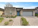 A modern single-story home with a well-manicured front yard and brick driveway leading to a two-car garage at 10001 Regency Square Ave, Las Vegas, NV 89148