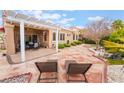 Charming backyard featuring a stone patio, covered pergola, lounge chairs and meticulously manicured landscaping at 10508 Snyder Ave, Las Vegas, NV 89134