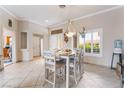 Bright dining area featuring a modern light fixture, neutral decor, and views of the front yard at 10508 Snyder Ave, Las Vegas, NV 89134