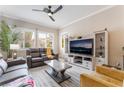 Comfortable living room with a ceiling fan, plantation shutters, and a large television for entertainment at 10508 Snyder Ave, Las Vegas, NV 89134