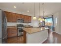 Bright kitchen with wood cabinets, stainless steel appliances, granite countertops, and a cozy dining area at 10548 Nantucket Ridge Ave, Las Vegas, NV 89166