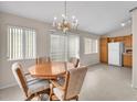 Bright dining room with chandelier, sliding glass door, and tile flooring at 1163 Teal Point Dr, Henderson, NV 89074