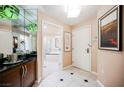 Inviting hallway featuring black and white tile, opening to a bathroom with a tub, vanity and front door at 135 E Harmon Ave # 1919, Las Vegas, NV 89109
