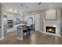 Gourmet kitchen featuring a center island, fireplace, pendant lighting, stainless steel appliances, and custom cabinetry at 15 Via Mantova # 303, Henderson, NV 89011