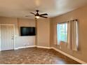 Cozy living room featuring tile flooring, a ceiling fan, a TV, and a bright window at 1501 Lake Placid Ter # 0, Henderson, NV 89014