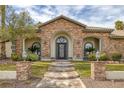 Inviting home entrance featuring a beautifully landscaped yard and stately brick columns at 1901 Rosemere Ct, Las Vegas, NV 89117