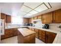 Well-lit kitchen boasts ample wood cabinetry, white tile countertops and backsplash, and a functional center island at 2004 Canterbury Dr, Las Vegas, NV 89119