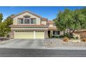 Charming stucco two-story home with a three car garage and manicured landscaping in the front yard at 2236 Midvale Ter, Henderson, NV 89074