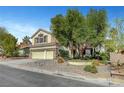 Charming stucco two-story home with a three car garage and manicured landscaping in the front yard at 2236 Midvale Ter, Henderson, NV 89074