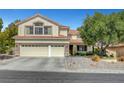 Daytime shot of a charming two-story home showcasing a three-car garage, mature trees, and manicured landscaping at 2236 Midvale Ter, Henderson, NV 89074