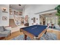 An open-concept living space with a pool table, staircase, chandelier, and elegant decor at 2236 Midvale Ter, Henderson, NV 89074