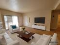Bright living room with wood floors, a large TV, and sliding glass doors for natural light at 3318 N Decatur Blvd # 1059, Las Vegas, NV 89130