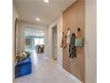 Modern entryway with a wood slat accent wall, tile flooring, blue bench and view into the living space at 506 Copper Falcon Ave, Henderson, NV 89011