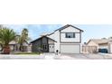 Beautiful two-story home boasting a modern black and white exterior, green lawn, and well-kept surroundings at 6407 Spring Meadow Dr, Las Vegas, NV 89103