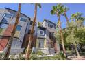 Unique multi-colored home with a modern exterior surrounded by lush landscaping and palm trees at 9050 W Tropicana Ave # 1178, Las Vegas, NV 89147