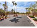 Gated community entrance with palm trees and landscaping at the end of a quiet street at 9445 Sweetwood Ave, Las Vegas, NV 89149