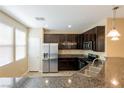 Kitchen with dark cabinets, stainless steel appliances, granite counters, and a stainless sink at 9445 Sweetwood Ave, Las Vegas, NV 89149