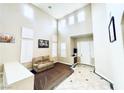 A large living room with high ceilings, an abundance of natural light, and a cozy seating area at 9670 Gentle Spirit Dr, Las Vegas, NV 89148